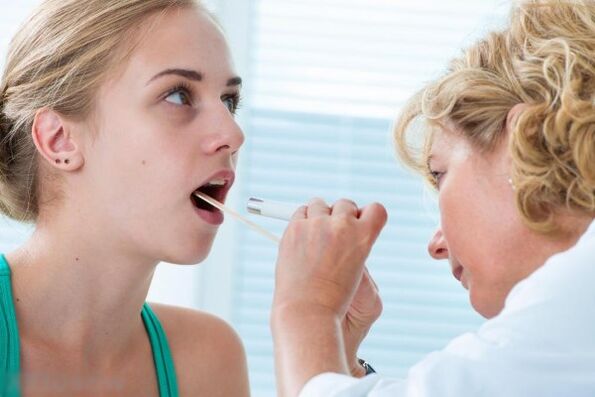 Doktor memeriksa rongga mulut untuk kehadiran papilloma